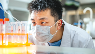 Chemist studying a pipette and test tube intently