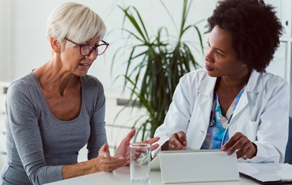 Older female patient talking with an African American female doctor