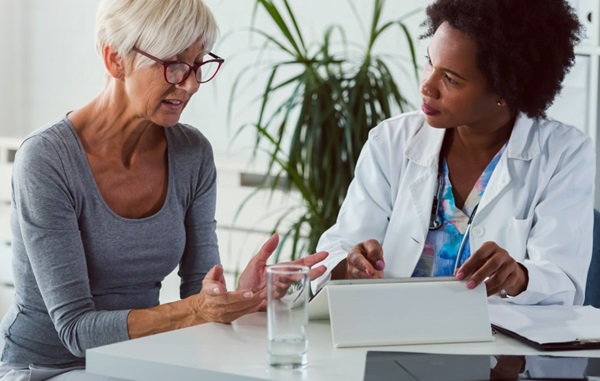 Older female patient talking with an African American female doctor