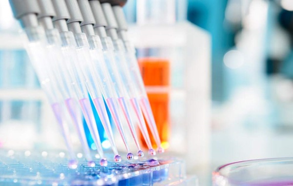 Medical syringes in lab with liquid bubbles forming on ends